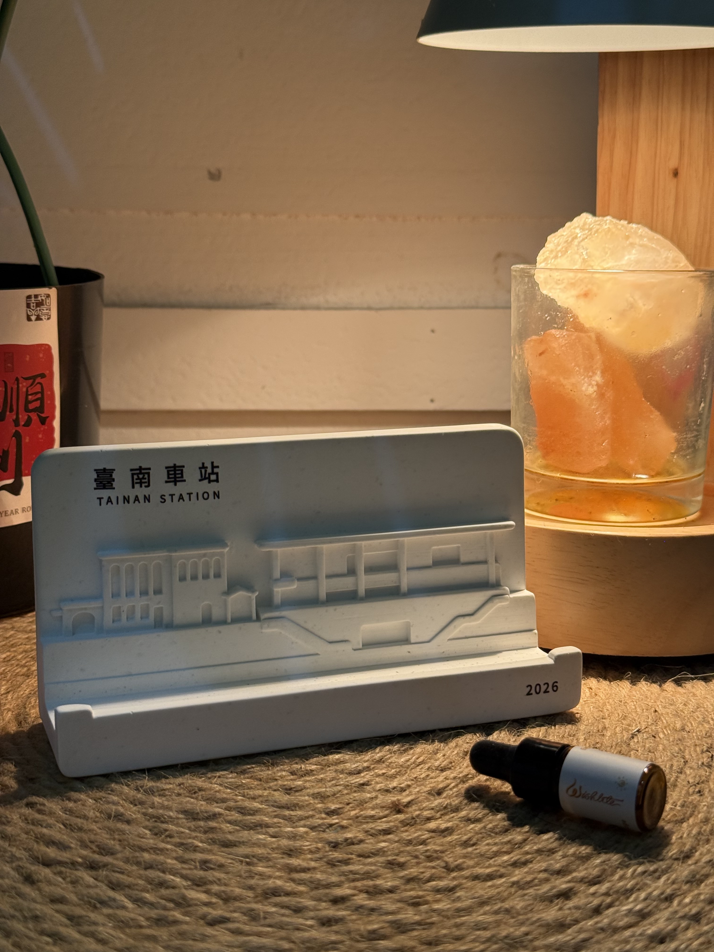 暖光下的臺南車站擴香石，新舊站建築以浮雕並列於作品上